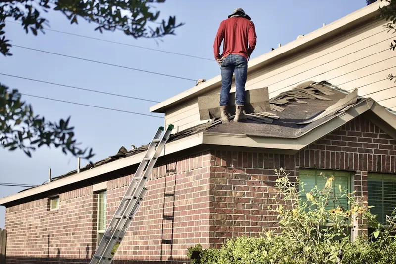 Professional roofer working on a residential roof in Mansfield Square